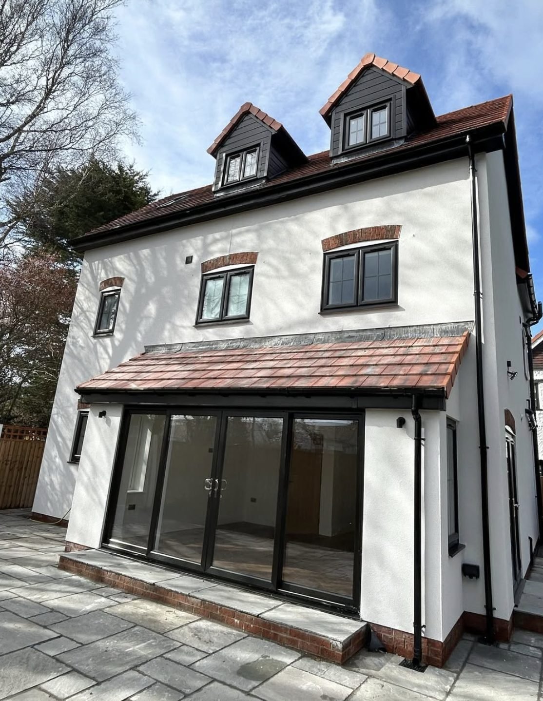 Three-storey back wall in white with dormers and a single-storey extension